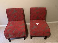 Front view showing two red fabric accent chairs with floral pattern and wood legs