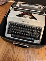 Front angle showing Olympia logo, keyboard layout, and part of carrying case.