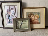 Three framed prints arranged on the floor, visible details of each artwork and frames.