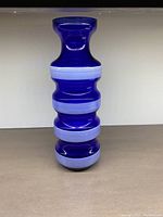 Front view of the cobalt blue glass vase showing white rings and segmented shape