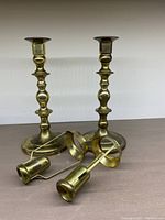 Full view of both brass candlesticks with their followers placed in front showing the overall shape and size.