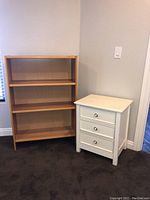 Bookshelf and white 3-drawer nightstand shown together against a wall