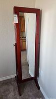 Full view of the cheval mirror standing upright showing the wooden frame and mirror surface