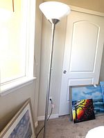 Full view of the floor lamp standing next to a window and door, showing its height and placement.