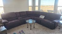 Full view of 6-piece brown sectional sofa beneath large windows