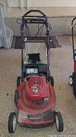 Front view of the red Toro lawn mower showing the handlebar and engine cover with 6.5 HP marking.
