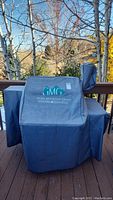 Fitted grey protective cover for Green Mountain Grills pellet grill with logo branding.