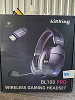 Box for the Gikking BL100 Pro wireless gaming headset showing the headset, USB wireless transmitter, and microphone; box states not Bluetooth enabled.