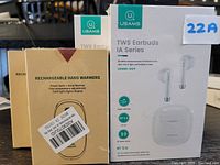 Photo showing packaging of 2 rechargeable handwarmers and 2 sets of USAMS True Wireless Earbuds IA Series with charging cases.