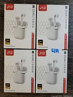 Photo showing 4 boxed sets of white J12 wireless earbuds with charging cases.
