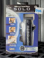 Front view of Microtouches Solo razor packaging showing product and key functions: trims, edges, shaves with one tool, dual-sided blades, hyper-advanced smart razor.