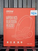 Front of box showing MPOW HC5 Bluetooth Headset branding and image of headset in white outline on orange background.