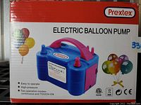 Front box image showing pump in blue with pink handle and two balloon inflation nozzles, branding, features including easy to operate, high pressure, and two operation modes.