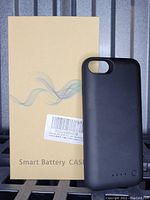 Black iPhone smart battery case positioned upright against original beige packaging box labeled 'Smart Battery Case'.