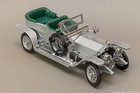 Front and side view of silver Rolls-Royce model with green seats and detailed exterior.