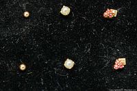 Photo showing all three pairs of earrings arranged on black fabric for display.