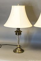 Single table lamp showing cut crystal column and metal base with off-white fabric shade