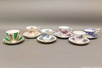 Front view of the six bone china teacup and saucer sets showing variety in floral patterns and gold trim.