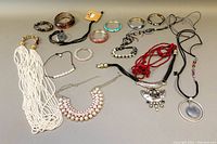 Photo showing all jewelry items including bangles and various necklaces on flat surface