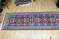Top view of one end of the Persian runner rug showing detailed pattern and colors.