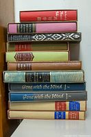 Full view of stack of 10 hardcover books showing variety of colors and titles