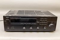 Front view of Yamaha RX-395 stereo receiver showing power button, headphone jack, speakers switch, tape monitor, tone controls, and tuner knob.