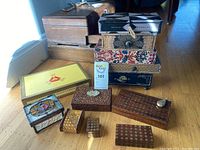 Collection of nine boxes arranged on wooden floor showing variety of materials and sizes.