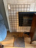 Full view of the standing metal grid panel used for belt display with floor base plate underneath (not included in sale).