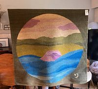 Full view of tapestry showing circular landscape motif against olive green background