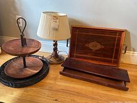 Photo showing twisted wood lamp, two-tiered wooden tea stand, inlaid wood tray, and wooden box