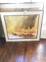 Front view of framed abstract mixed media painting leaning against window