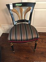 Ornate chair front view displaying decorative gold leaf back support and striped seat upholstery.