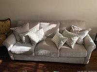 Front view of couch with six accent pillows on hardwood floor