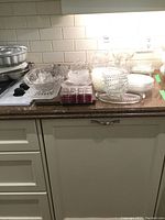Wide view showing the glass serving ware including the six fruit nappies, glass tray, napkin saucers, and salt and pepper shakers in packaging.