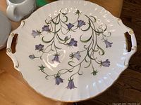 White porcelain Spode serving platter with purple Campanula flowers, gold trim, and two handled sides.