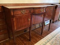 Full front view showing three drawers above three cabinet doors on tapered legs