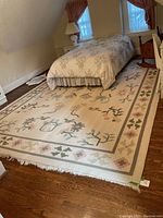 Overall view of rug placed under bed showing full pattern and size