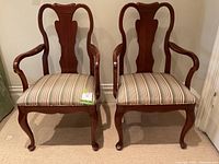 Front view of both chairs, showing carved crest, arms and upholstery