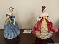 Pair of Royal Doulton porcelain figurines including Southern Belle and Andrienne on display