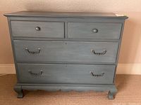 Front view of pale blue dresser showing four drawers and hardware