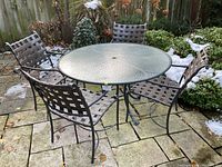 Overview of entire set: round table and four chairs on stone patio