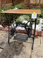 Front angle view of entire table showing cast iron base and oak top