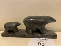 Front view showing mother and cub on base with carved signature and date