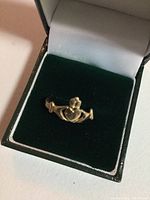Ring in green velvet box showing front Claddagh design