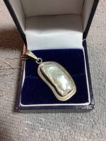 Close-up of sterling silver Mabe pearl pendant inside a presentation box showing the pearl's unique shape and lumpy nacre.