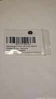 Photo of natural oval pink-purple sapphire inside a clear plastic bag with printed label showing carat weight, clarity, origin, and treatment details.