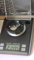 Three natural gemstones on black weighing scale showing total weight of 21.495 carats