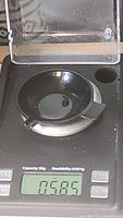 Photo showing the sapphire on a digital scale displaying weight of 0.585 carats.