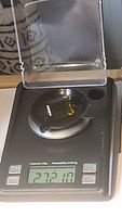 Photo of the gemstone on a digital scale showing weight of 27.21 carats, confirming the large size.