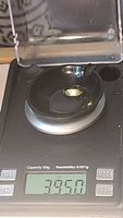 Photo showing the 3.95 carat weight and scale of the oval cut lemon citrine gemstone on a precision digital scale.
